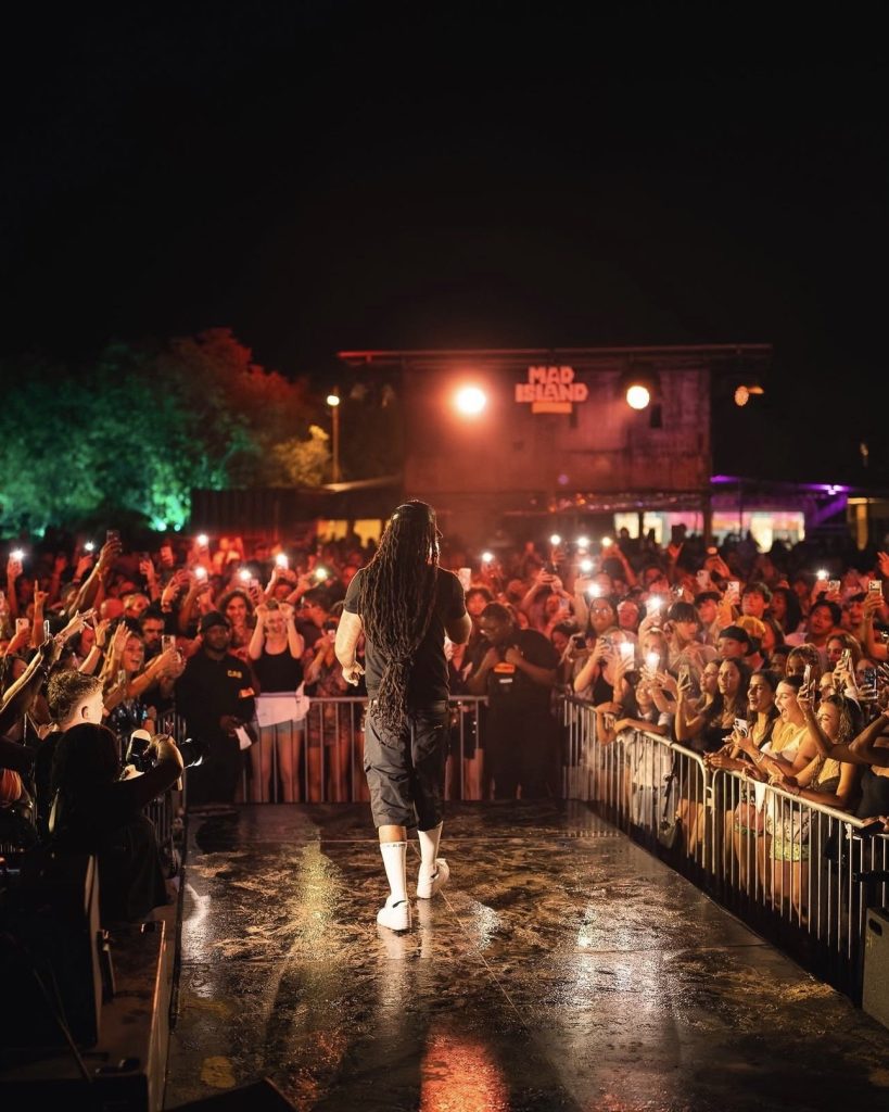 Artist on stage facing a packed crowd